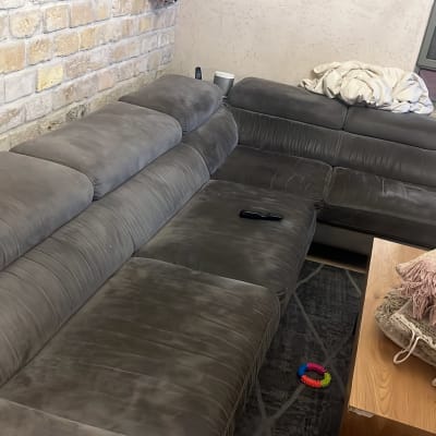 ספה אפורה עם כריות ושלט על השולחן