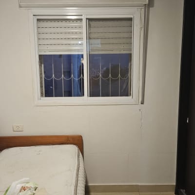 חלון עם תריסים סגורים ומסגרת לבנה