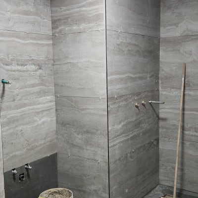 חדר אמבטיה בשיפוץ עם אריחים, דלי ומטאטא