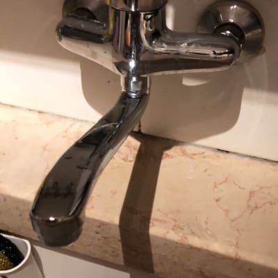 ברז מתכת מותקן על קיר מעל כיור