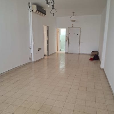 חדר ריק עם רצפה נקייה ותאורה תלויה