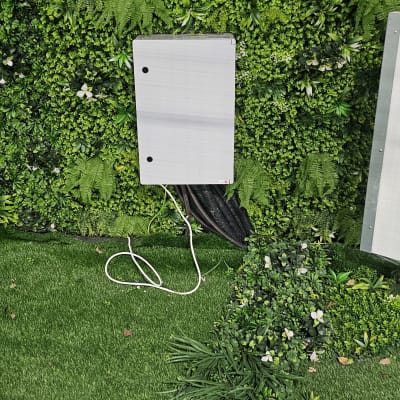 קופסת חשמל עם כבלים על רקע קיר ירוק