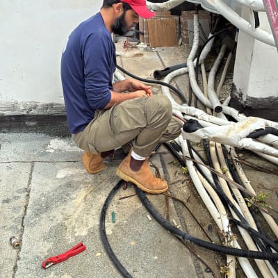 אדם עובד על צינורות ומערכות חימום על גג