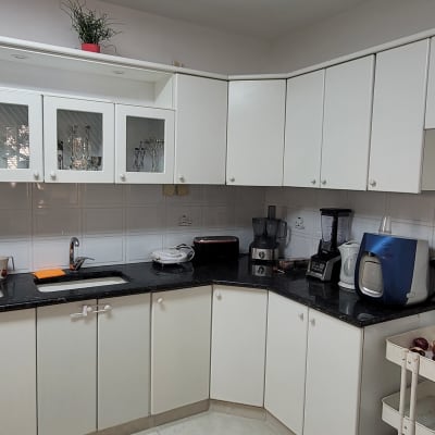 מטבח עם ארונות לבנים, מכשירי חשמל על השיש