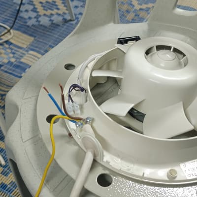 מאוורר עם חוטי חשמל על כיסא פלסטיק