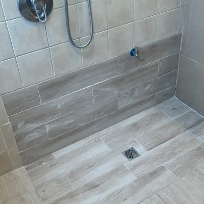 מקלחת עם אריחים חדשים וברזים מותקנים