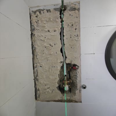 צנרת חשופה בקיר עם סימון לייזר ירוק