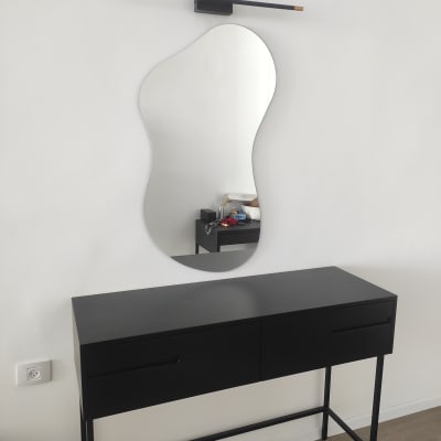 שולחן שחור עם מראה מעוצבת על הקיר