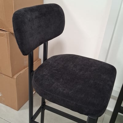 כיסא מרופד שחור ליד קופסאות קרטון