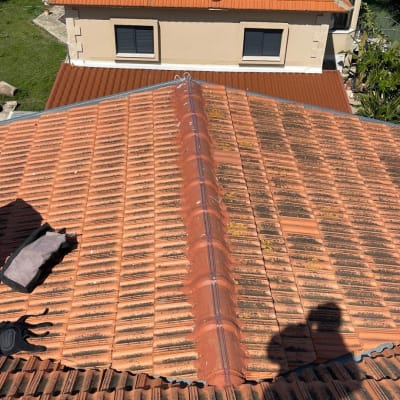 גג רעפים עם צל של אדם וכלי עבודה