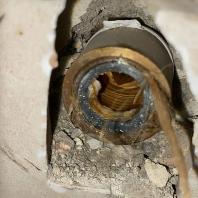 צינור מתכת חשוף בקיר עם חוטים