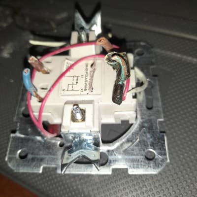 חוטי חשמל מחוברים למתג חשמלי על לוח מתכת