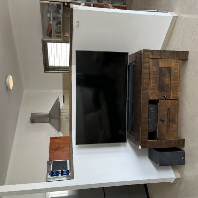 טלוויזיה על קיר לבן עם ארון עץ כהה