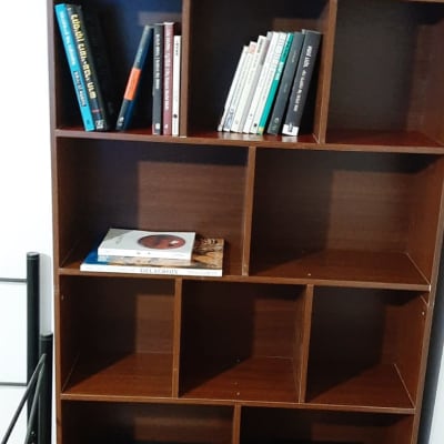 מדף ספרים מעץ עם ספרים שונים