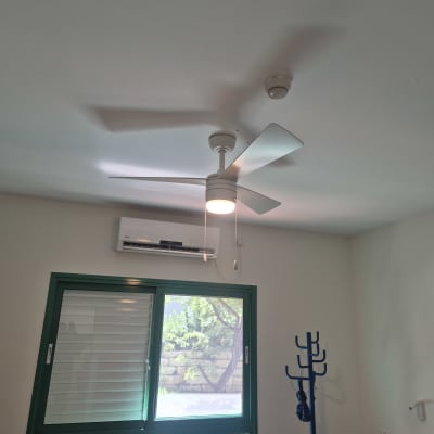 מאוורר תקרה ומזגן בחדר עם חלון
