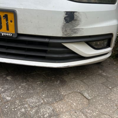 פגוש רכב לבן עם שריטות ושפשופים