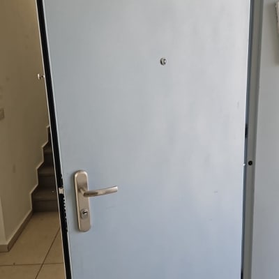 דלת מתכת פתוחה עם ידית כסופה