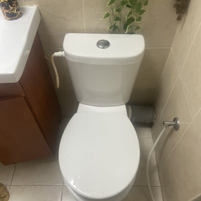 אסלה עם צינור מים מחובר לקיר