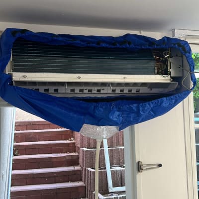 מזגן מפורק עם כיסוי כחול לתחזוקה