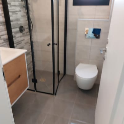 חדר אמבטיה נקי עם מקלחון ושירותים