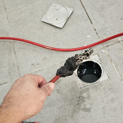 פתיחת סתימה בפתח ניקוז רצפתי בבית באמצעות כבל פתיחת סתימות