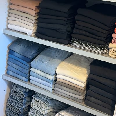 בגדים מקופלים ומסודרים על מדפים בארון