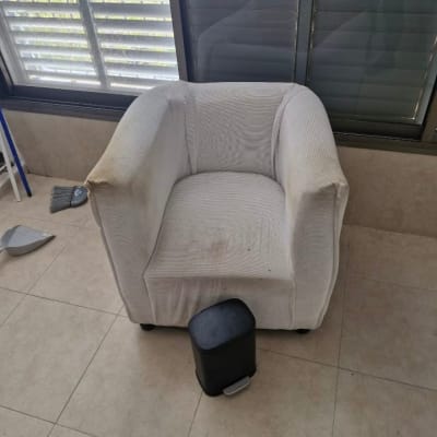 כיסא מרופד עם כתמים, פח אשפה קטן, מטאטא ויעה