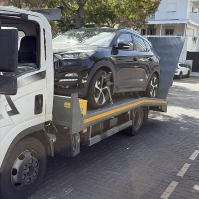 רכב על גרר ברחוב עם עצים ברקע