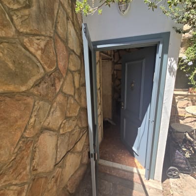 דלת אלומיניום כחולה פתוחה בקיר אבן