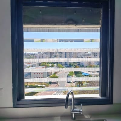 חלון אלומיניום עם נוף עירוני וברז מטבח