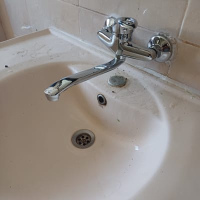 ברז כרום מותקן על קיר מעל כיור לבן