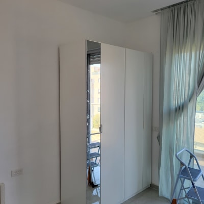 ארון לבן עם מראה וסולם מתקפל בחדר