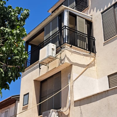 מרפסת עם מסגרות חלונות ומזגן על קיר חיצוני