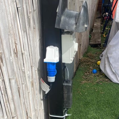 שקע חשמלי כחול על עמוד שחור עם כבלים