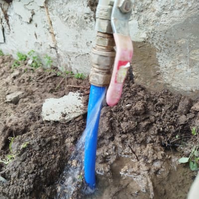 צינור מים כחול עם ברז דולף באדמה