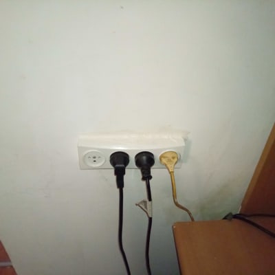 שקע חשמל עם שלושה תקעים מחוברים לקיר