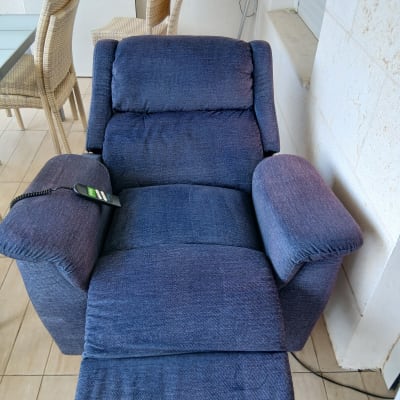 כורסה מרופדת בצבע כחול עם שלט על משענת היד