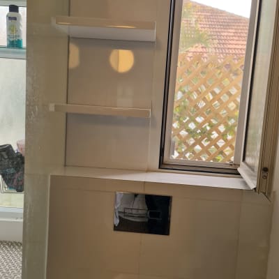 מדף עץ לבן מותקן על קיר לבן