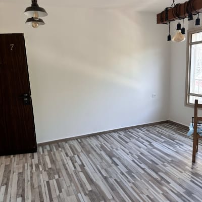 קיר לבן צבוע בחדר עם רצפת עץ