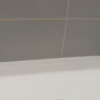 איטום בסיליקון לבן בחיבור בין אריחי הקיר לאמבטיה או כיור