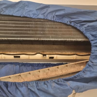 מזגן מפורק עם כיסוי כחול לניקוי