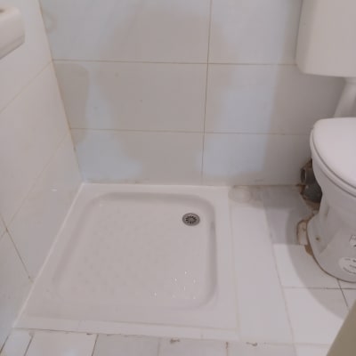 מקלחון חדש עם ריצוף לבן ואסלה בצד