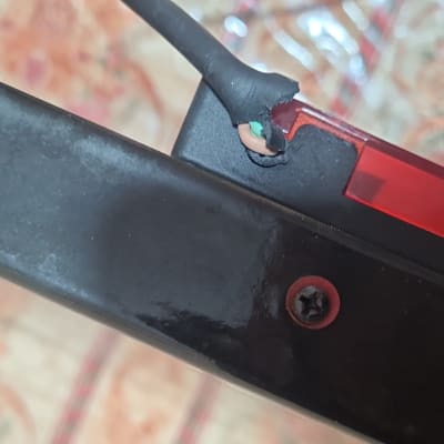 חוט חשמל חשוף עם בידוד קרוע וחלק פלסטיק אדום