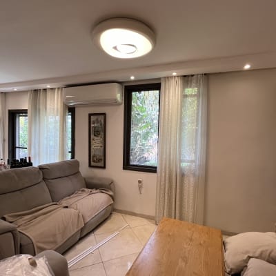 וילונות לבנים שקופים תלויים על חלונות בסלון