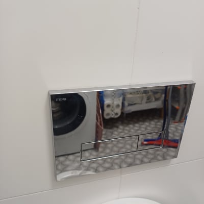 לחצן הדחה כסוף על קיר לבן