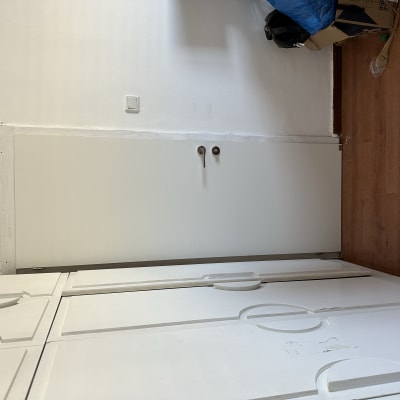 דלת לבנה עם ידיות מתכת על רצפת עץ