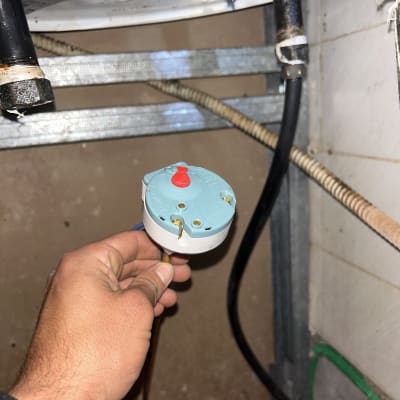 יד מחזיקה תרמוסטט של דוד שמש מתחת לדוד