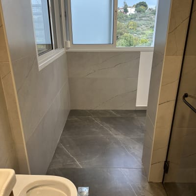 שירותים נקיים עם רצפה מבריקה וחלון פתוח