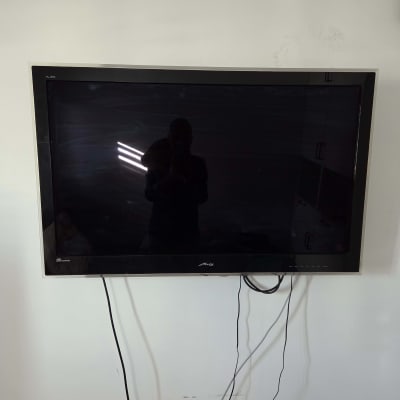 טלוויזיה מותקנת על קיר עם כבלים גלויים