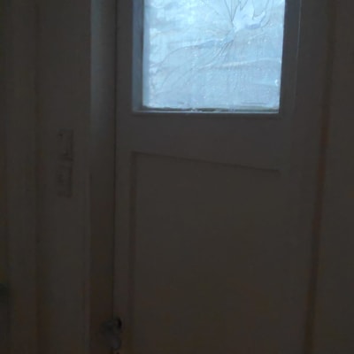 זכוכית סדוקה בחלון דלת עץ לבנה